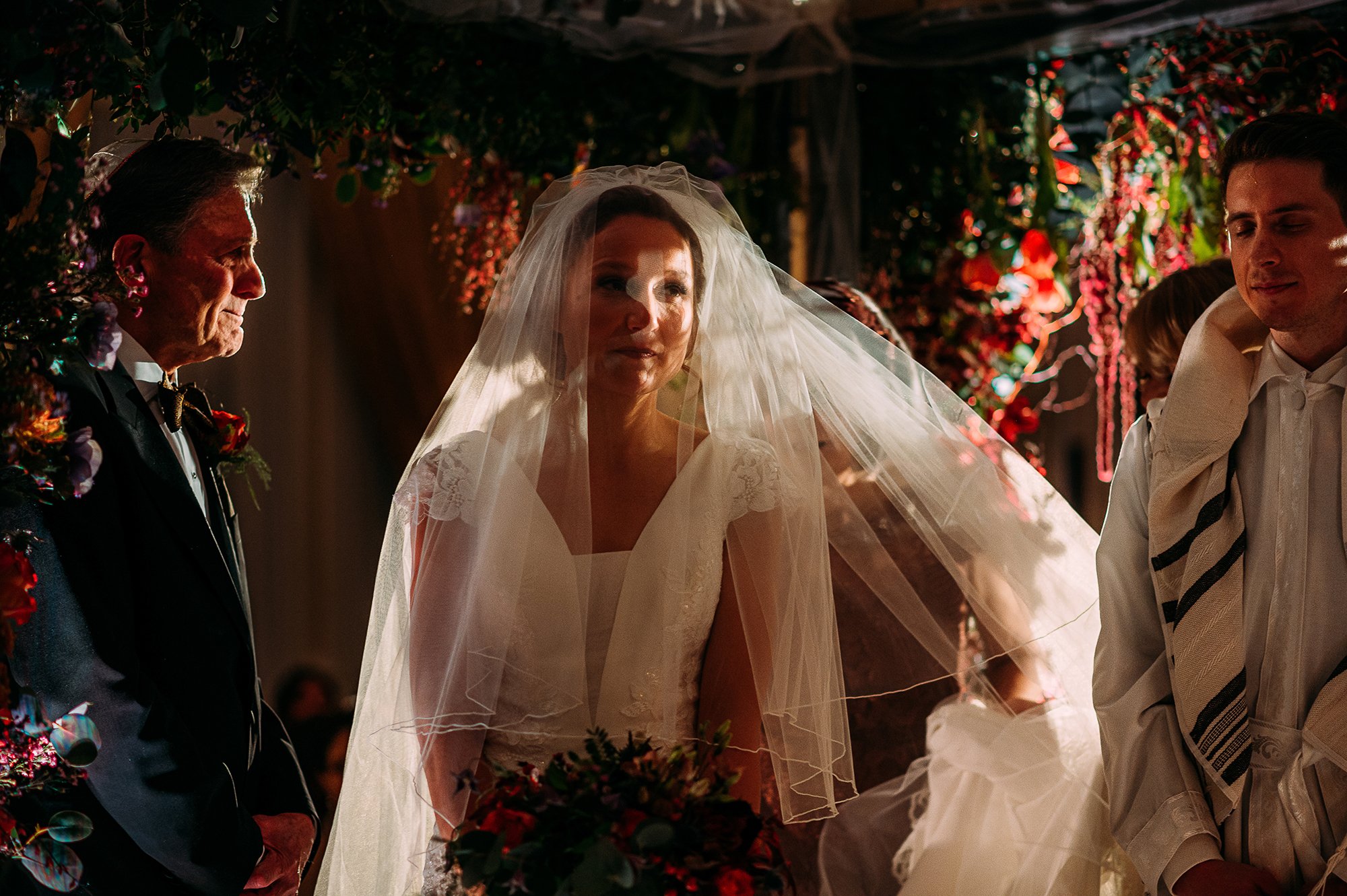  Light hitting the brides eyes as she walks around her husband under the Chuppah. 