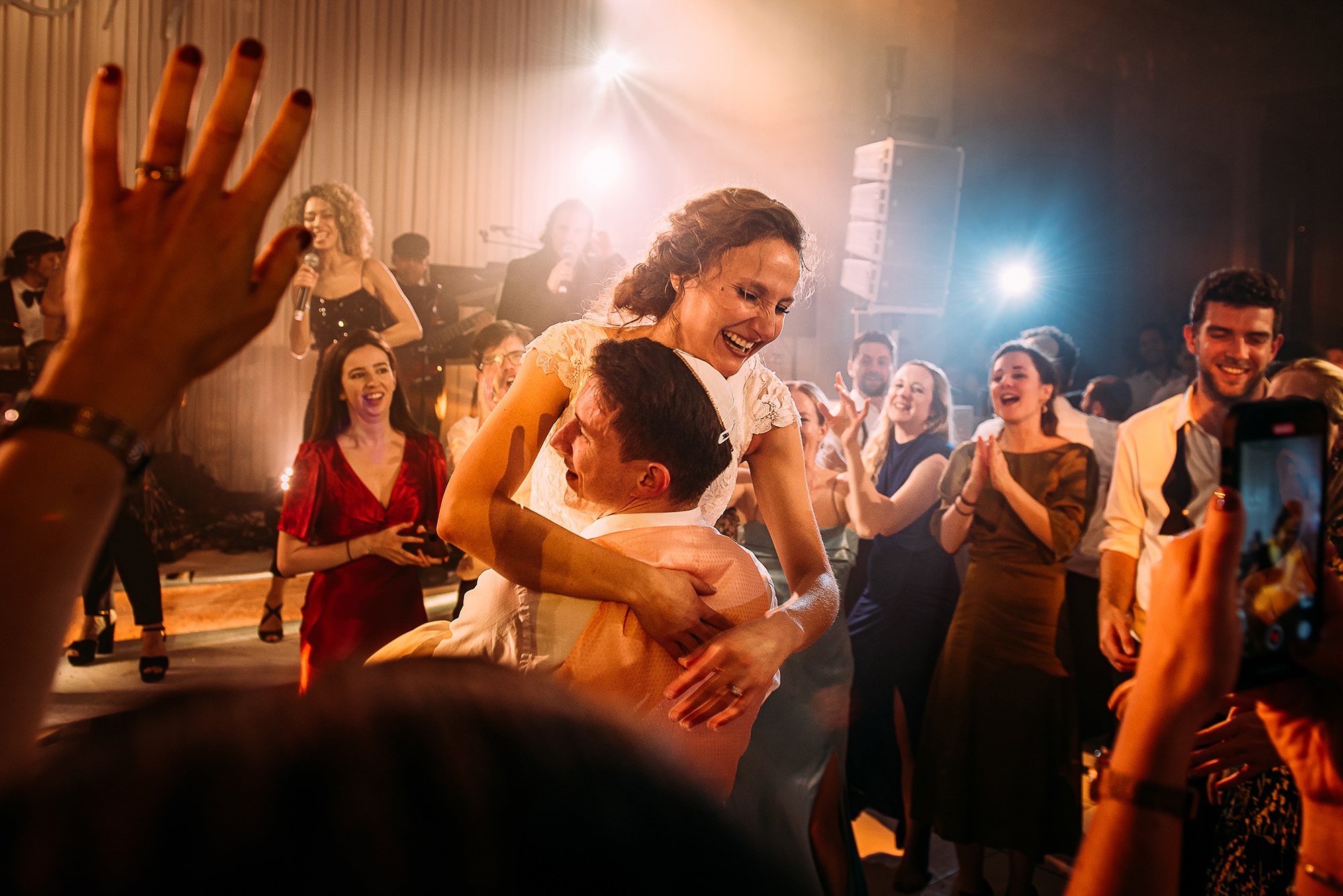  Groom lifts bride in the middle of a packed dance floor. 