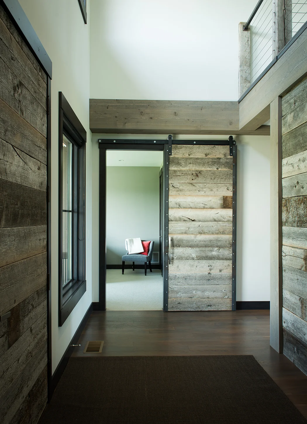 I love all the barn wood and the sliding doors. The chair draws your eye right into the guest bedroom of this stunning home. 