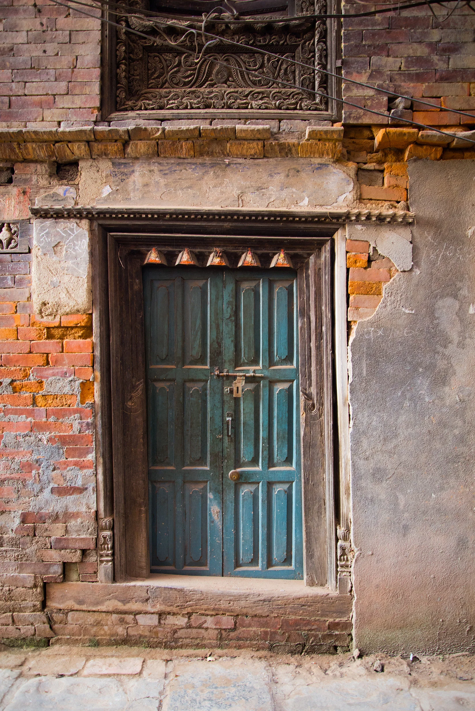 The contrast in color from the door to the bricks is gorgeous. I love all the detail in the frame, also the cracks leading up the side of the building. It's beautiful!