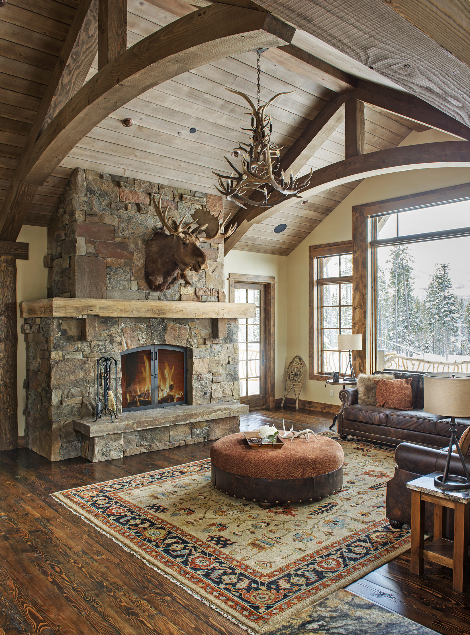 The fireplace, wood paneling on the ceiling, and the animal antler decor that adds to the rustic feel. Architect - Centre Sky Architecture . Builder - Dovetail Construction 