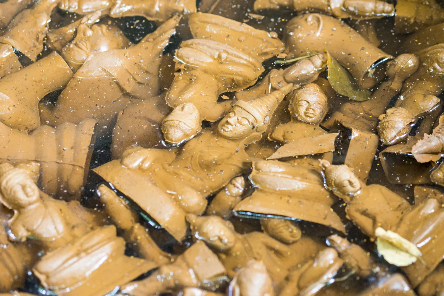 Bronze figures submerged in clay moulds