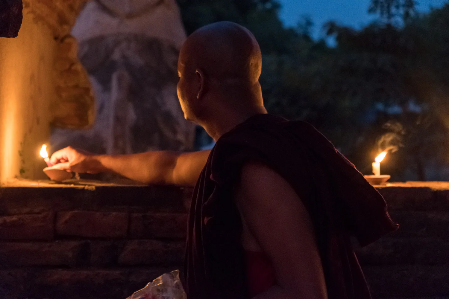 Monk lighting candles at the chanting ceremony