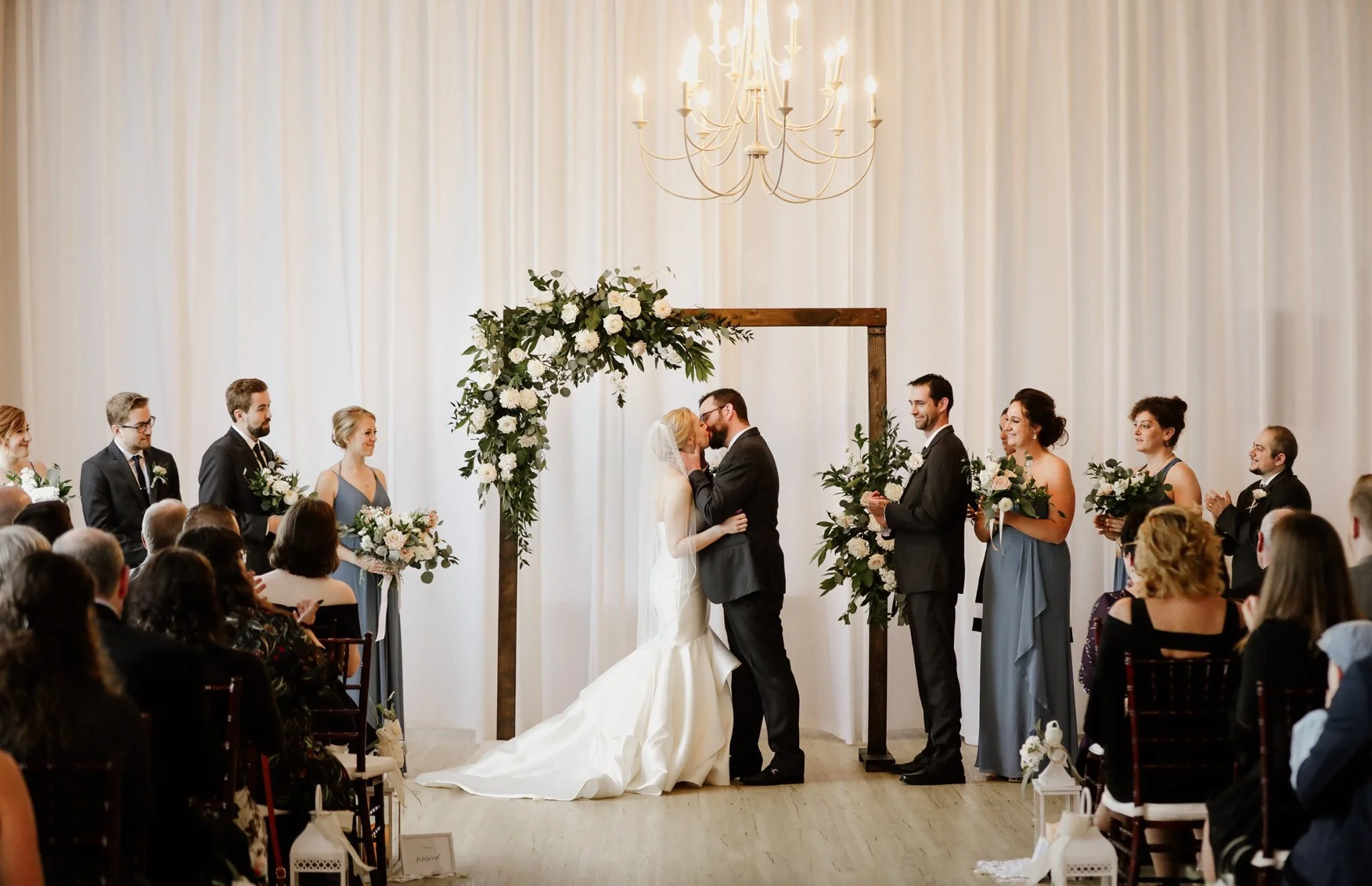 Bride and groom kissing at the altar during a wedding ceremony at an elegant Rochester NY venue served by Sound Express Entertainment