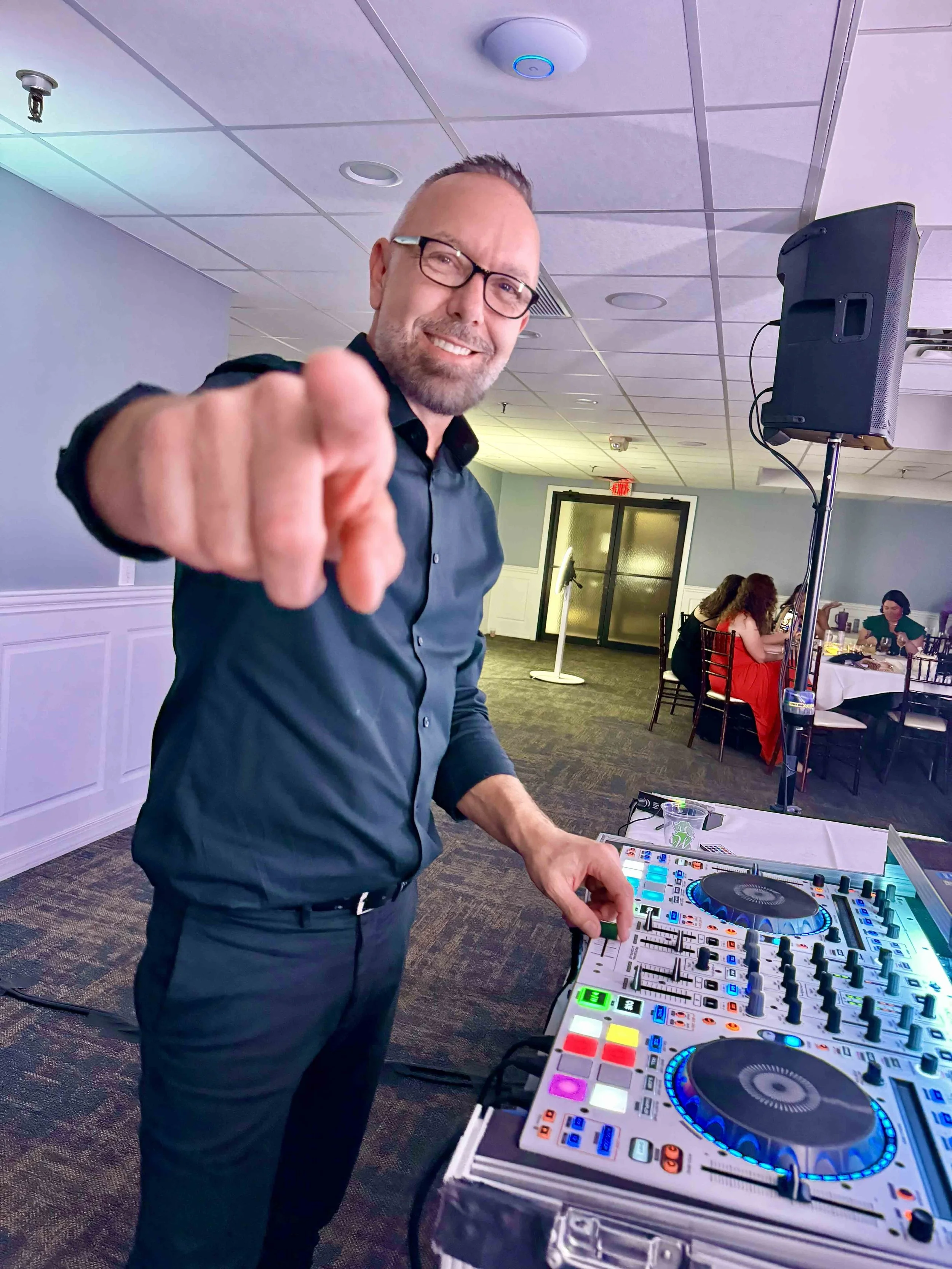 David Pfluke, owner of Sound Express Entertainment, pointing at the camera while DJing an event at Webster Golf Club in Webster, NY.