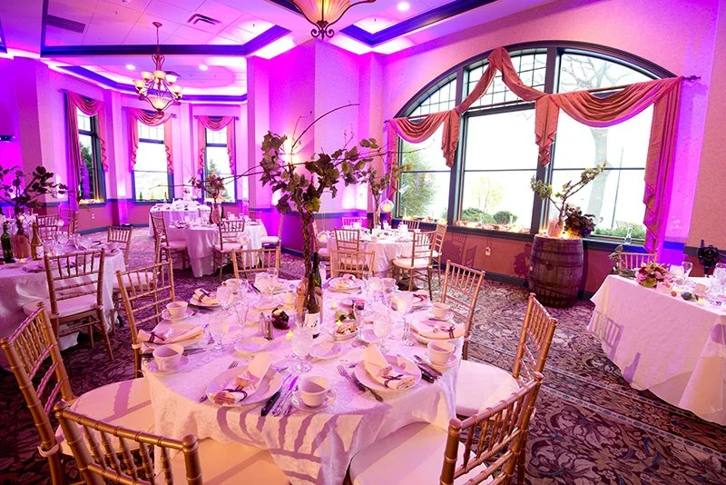 Transform your reception with professional LED uplighting. This stunning setup at Belhurst Castle in Geneva, NY, shows how vibrant purple tones can create a romantic and modern atmosphere in a historic venue.