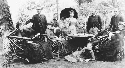 A family picnic at Forest Hill, circa 1880. Rockefeller stands at far left. Daughters Bessie, left, and Edith, right, sit directly behind the table, while Alta lounges impishly below. Cettie sits at far left and Grandmother Spelman at far right. (Courtesy of the Rockefeller Archive Center)