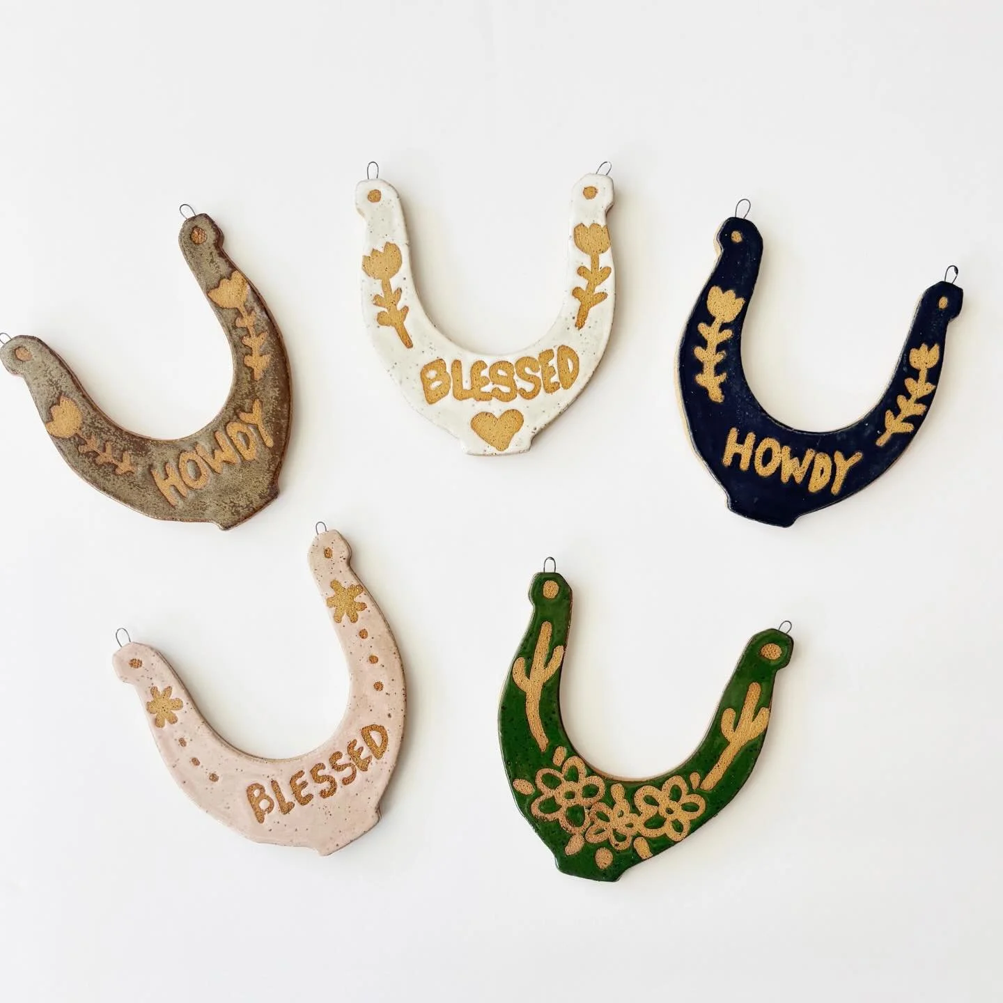 Horsin&rsquo; around in the studio and these cuties are ready to hang 🤠✨
Handmade ceramic horseshoe wall hangings featuring a little howdy, a whole lotta blessed, and some desert darlings 🌵🌸
Good luck charm? Western flair? Tiny yeehaw moment? Yes.