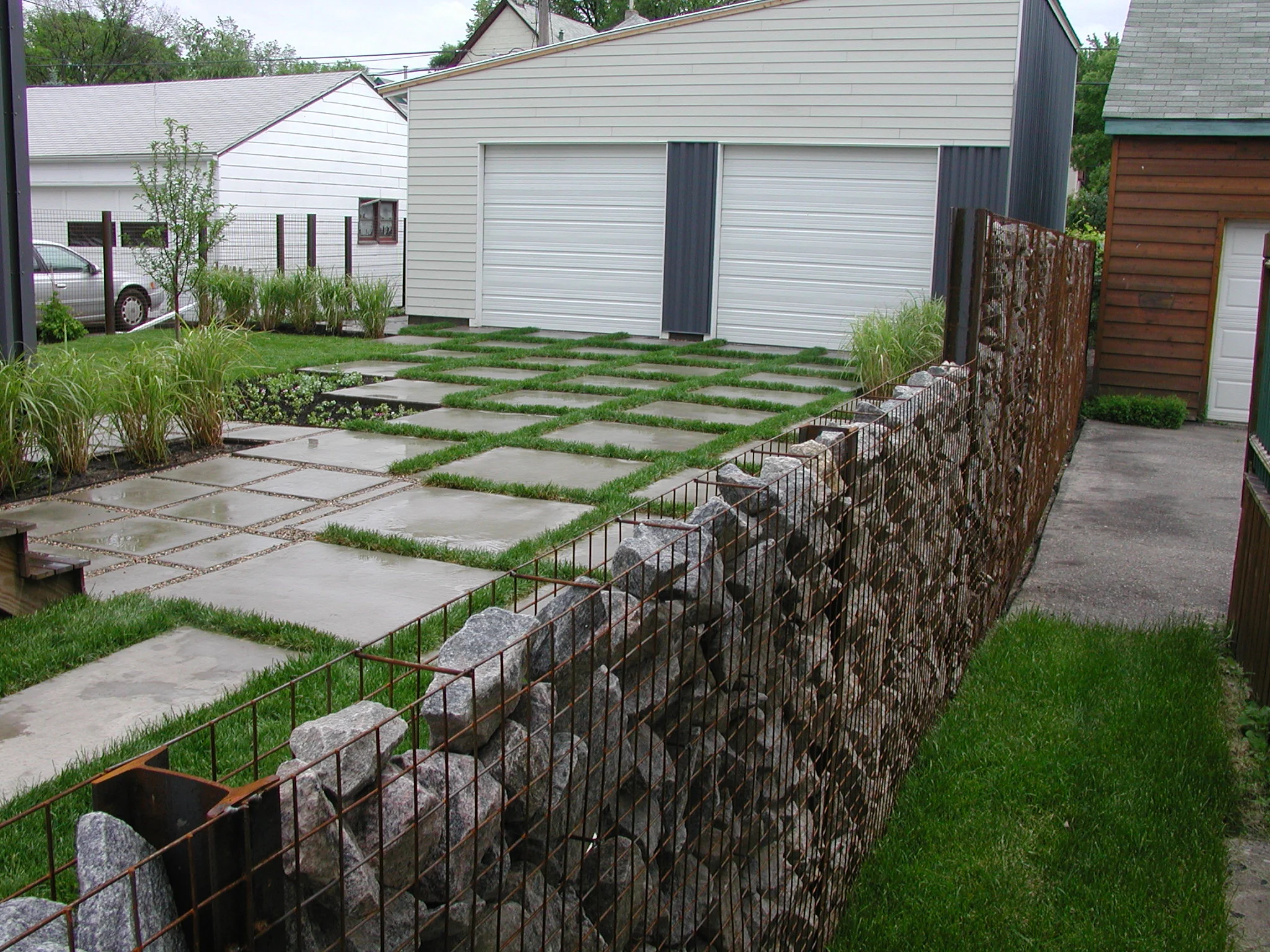  Grand Street backyard landscape. &nbsp;Custom gabion fence and poured concrete pavers with high fly ash content.  Collaboration with  rolu  