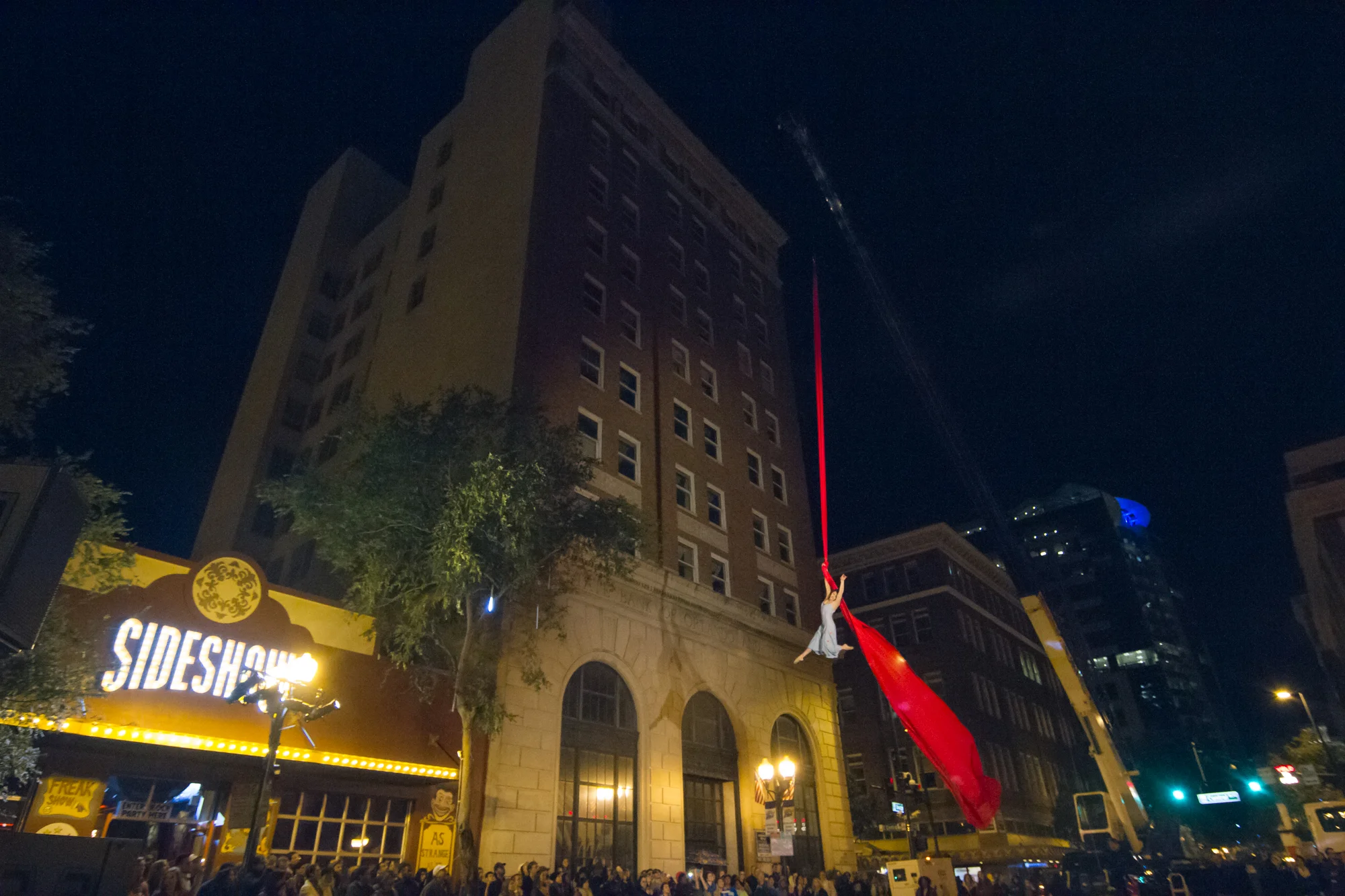 A silks performer high over a downtown street at the Creative City Project's annual event, now named, IMMERSE.