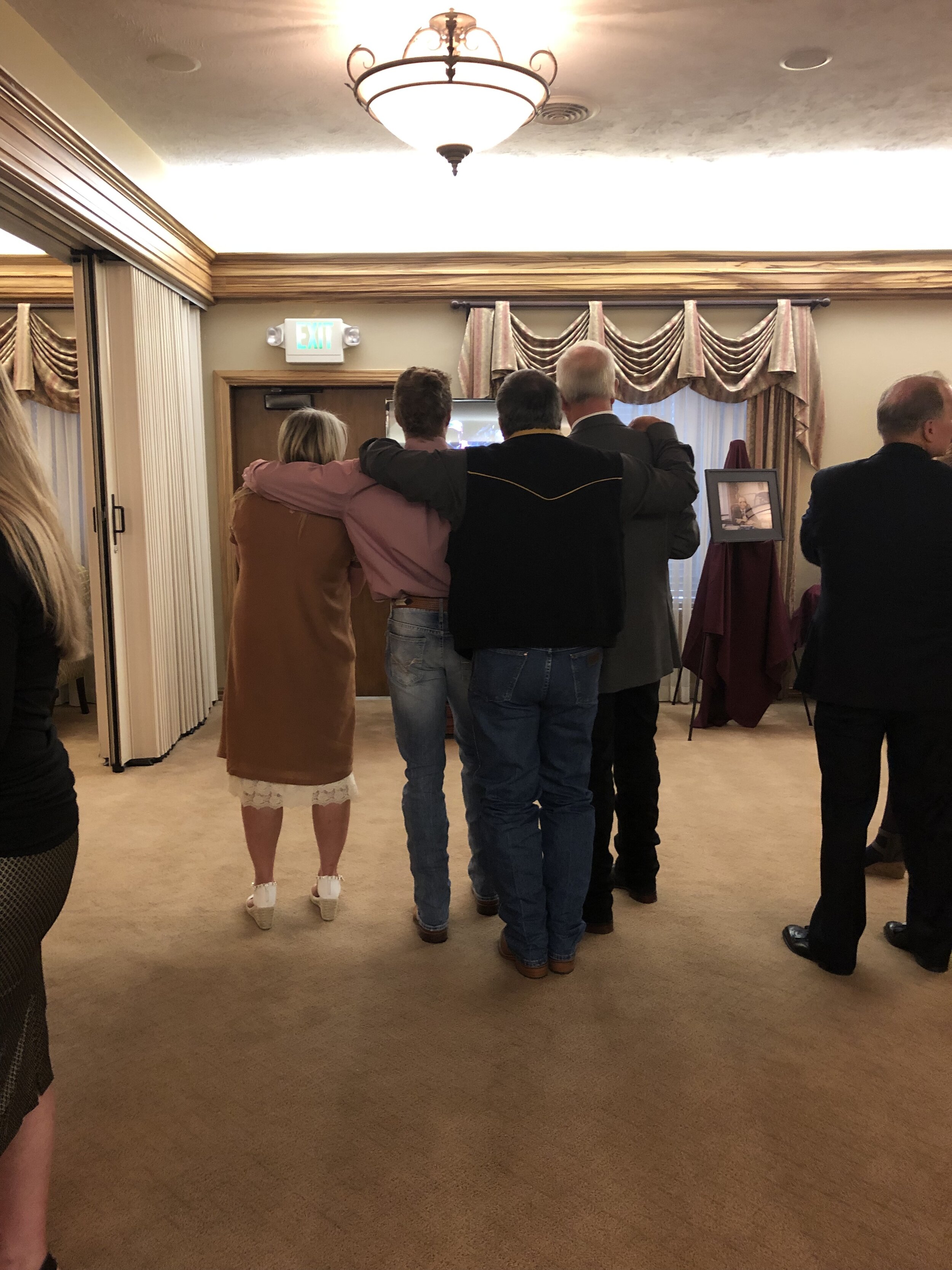 Some of my family watching a slideshow of grandpa at his viewing.