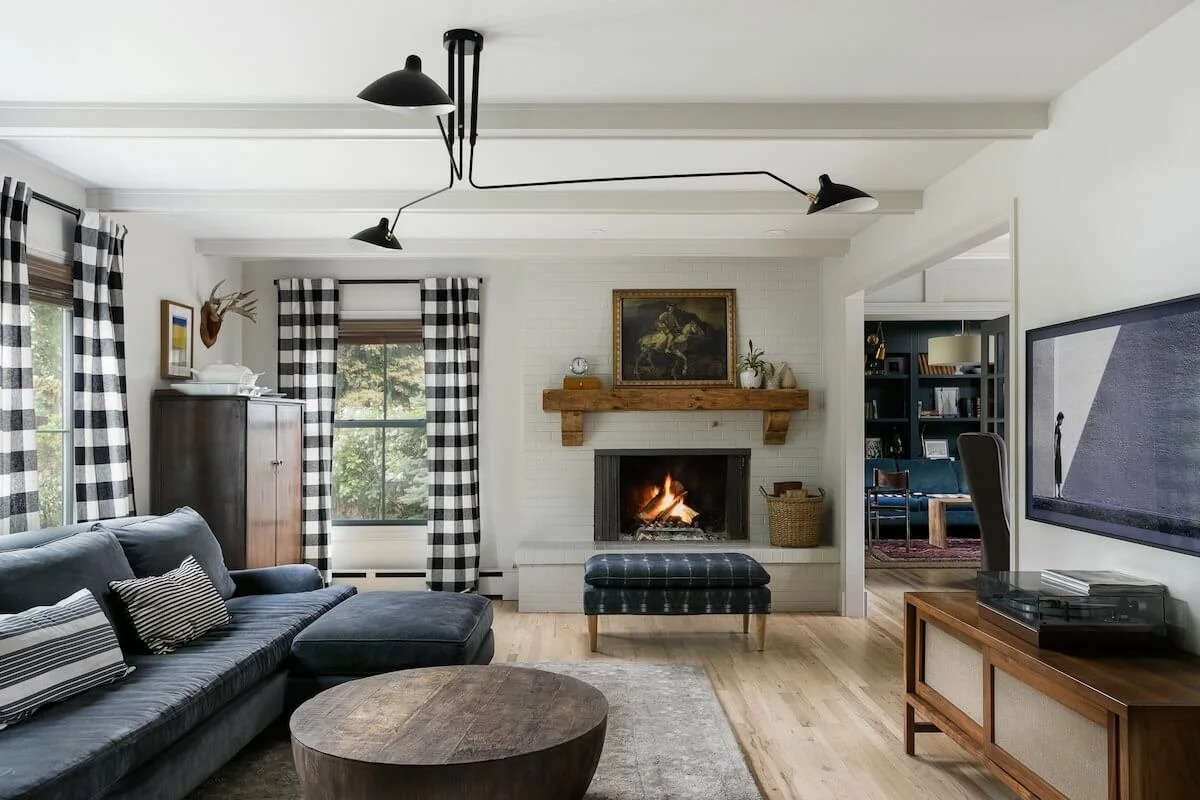 Fort Collins interior photography of a Colorado living room with white brick fireplace, plaid curtains, and modern sectional sofa.