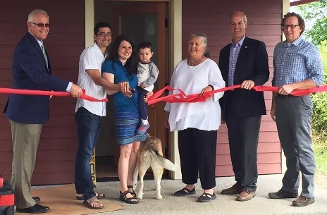 From left to right; Whatcom County Executive Jack Louws, new homeowners Joseph Hill, Megan Grosshuesch and Calvin Hill, Mayor Linville, Congressman Rick Larsen, and Executive Director of KulshanCLT, Dean Fearing, cut the ribbon on Monday, June 22, at the newly dedicated eco-friendly land trust home. 