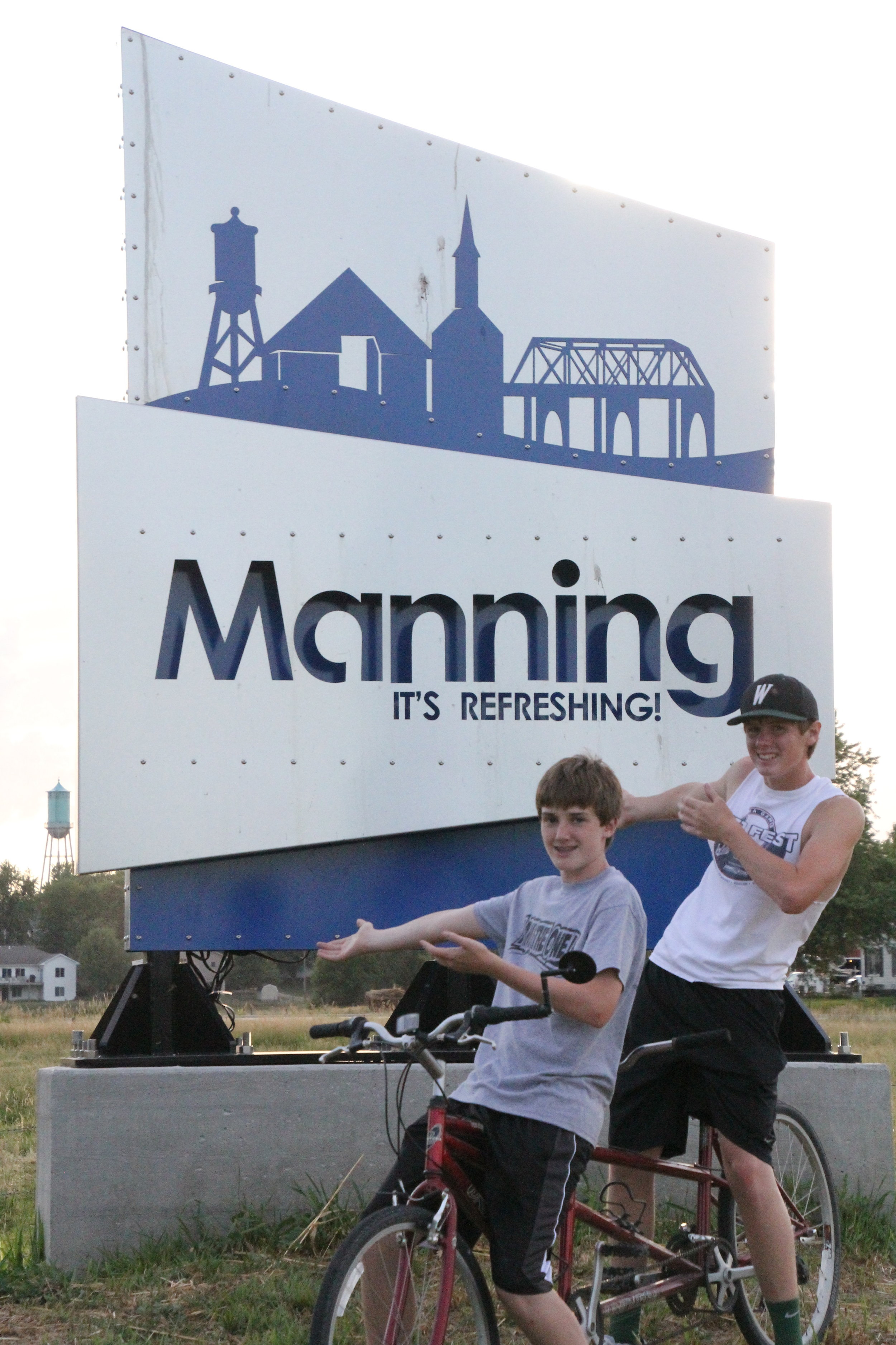 Welcome To Manning Sign w boys on bikes.JPG