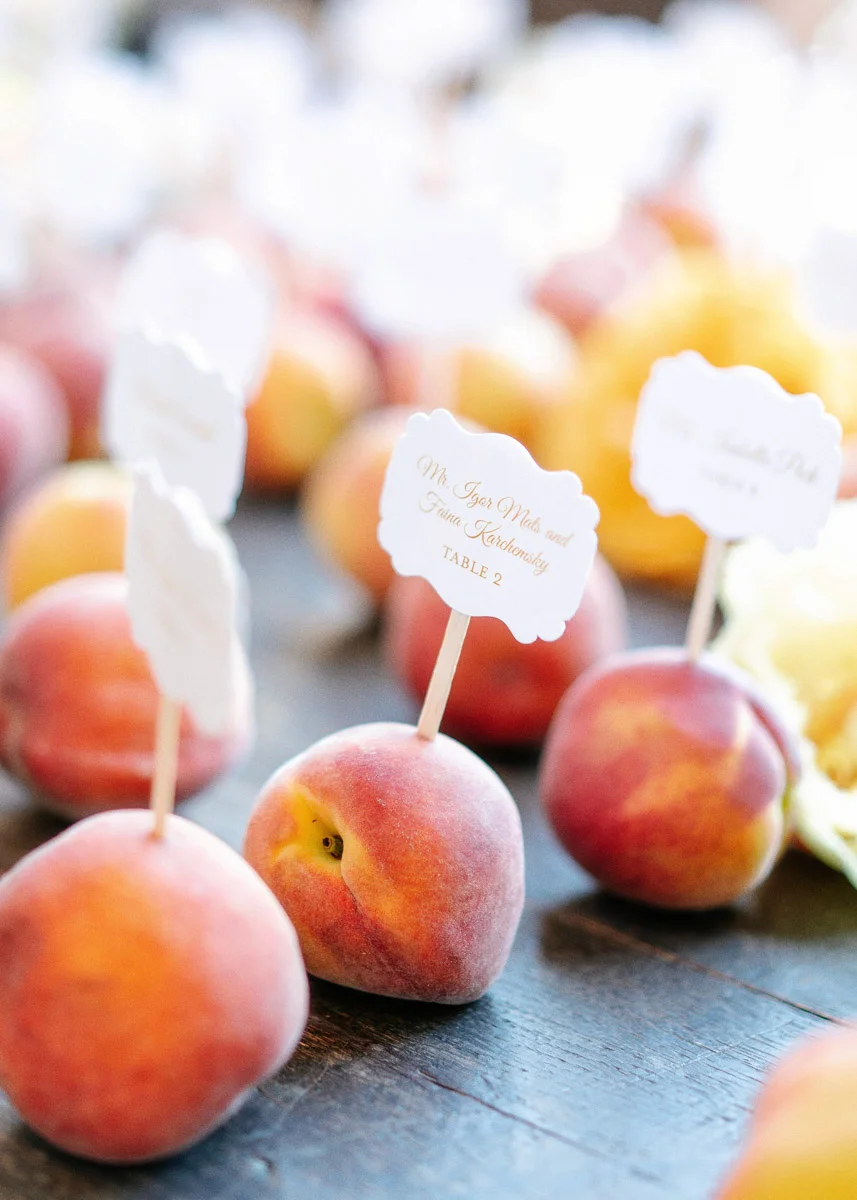 Fresh peach seating card display at a summer garden wedding designed by Eddie Zaratsian