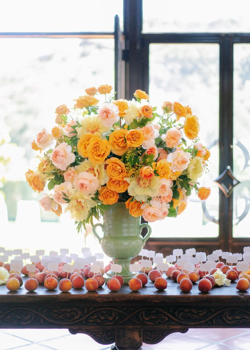 Peach seating card display at a summer garden wedding designed by Eddie Zaratsian