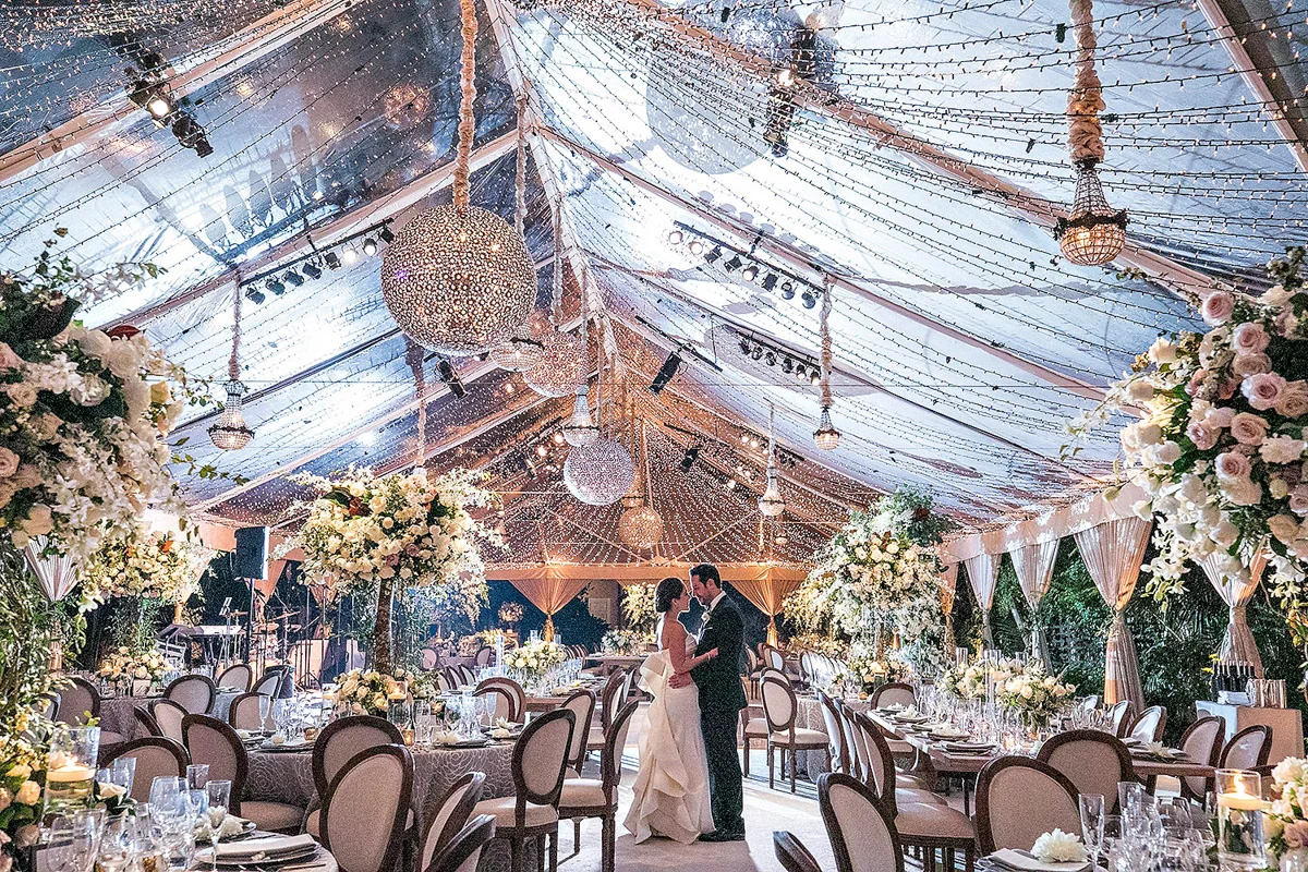 Hotel Bel-Air wedding reception tent with chandeliers and string lights, florals designed by Eddie Zaratsian, Photo by Jessica Claire Photography
