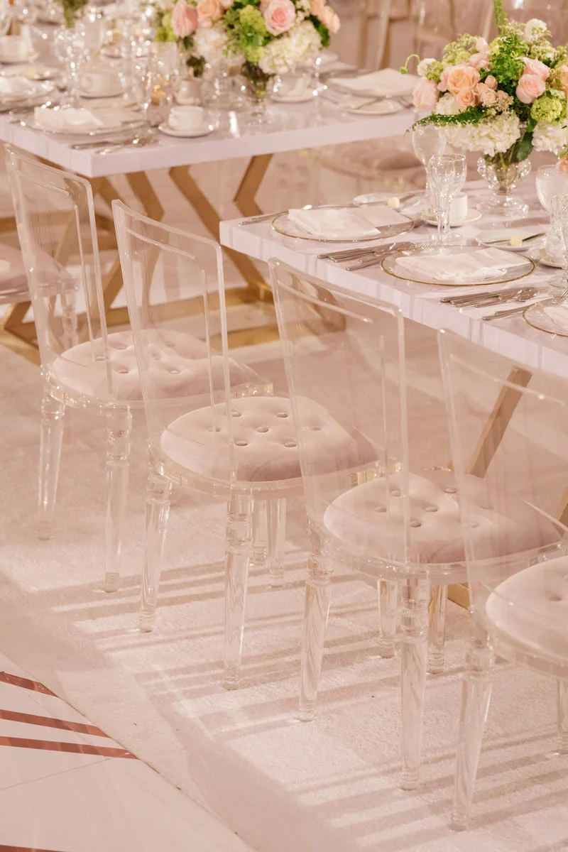 Wedding reception tables with translucent dining chairs and pink, white and copper accents - designed by Eddie Zaratsian, photo by Kris Kan