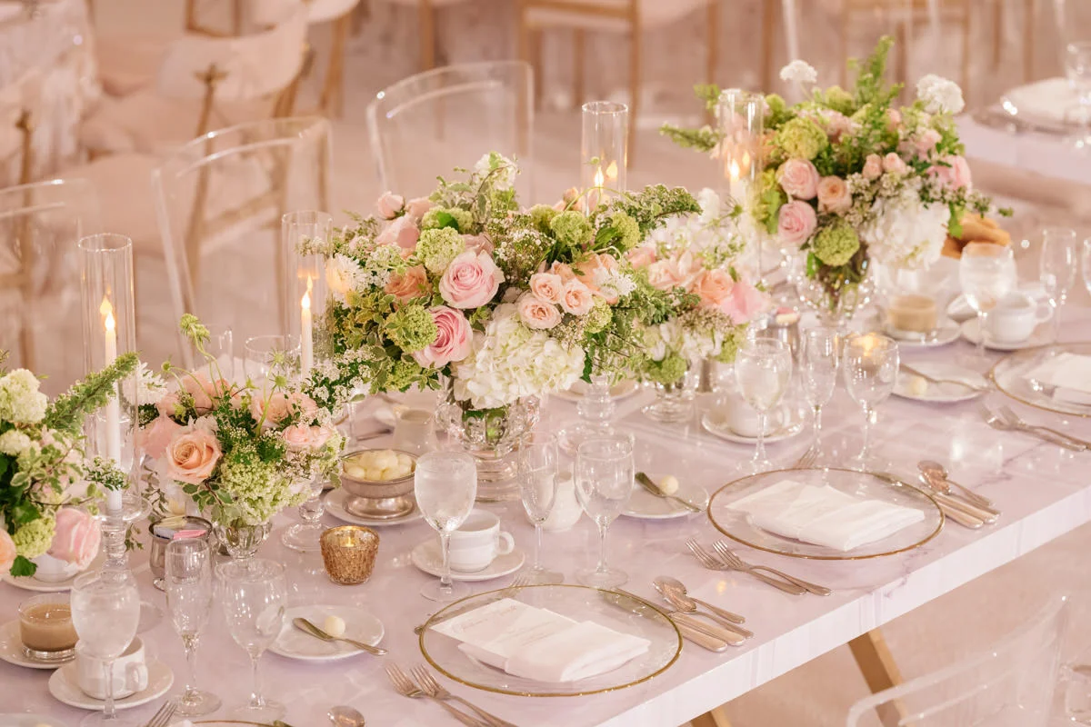Wedding reception tables with translucent chairs, vases and candle holders, pink and white florals, and copper accents - designed by Eddie Zaratsian, photo by Kris Kan