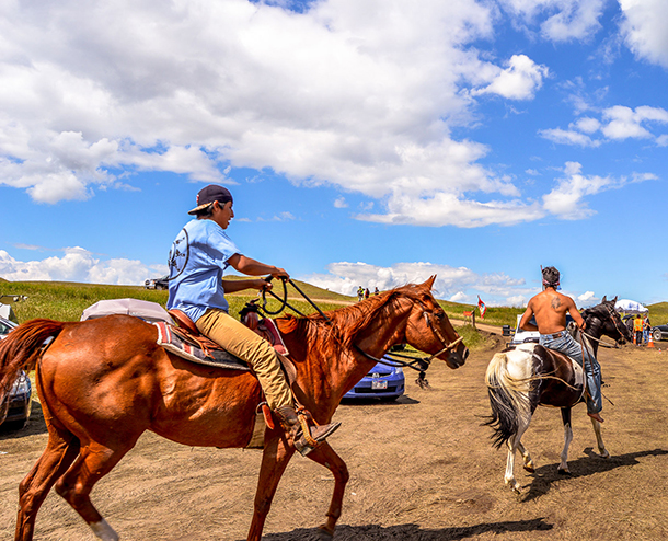 Two Standing Rock demonstrators take to horseback as part of the Standing Rock demonstrations that peaked in 2016. (Photo: Robert Wilson, via PRI)