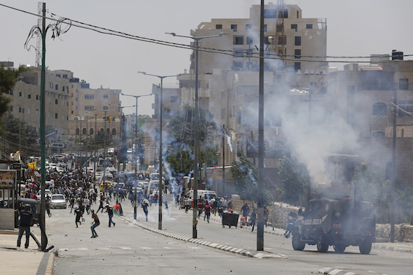  An Israeli security vehicle fires tear gas during clashes with Palestinians demonstrating in the West Bank city of Bethlehem in May. (Nasser Shiyoukhi / AP) via Truthdig