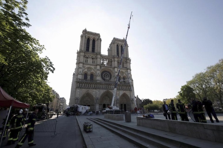 A crane works at Notre-Dame cathedral in Paris, Friday, April 19, 2019. Rebuilding Notre Dame, the 800-year-old Paris cathedral devastated by fire last week, will cost billions of dollars as architects, historians and artisans work to preserve the medieval landmark.
