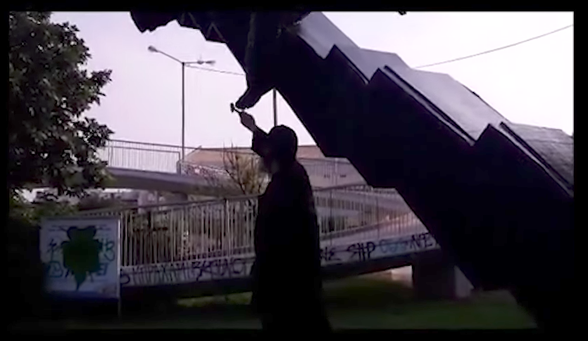 YouTube still of "Priest Kleomenis" damaging the artwork with a hammer