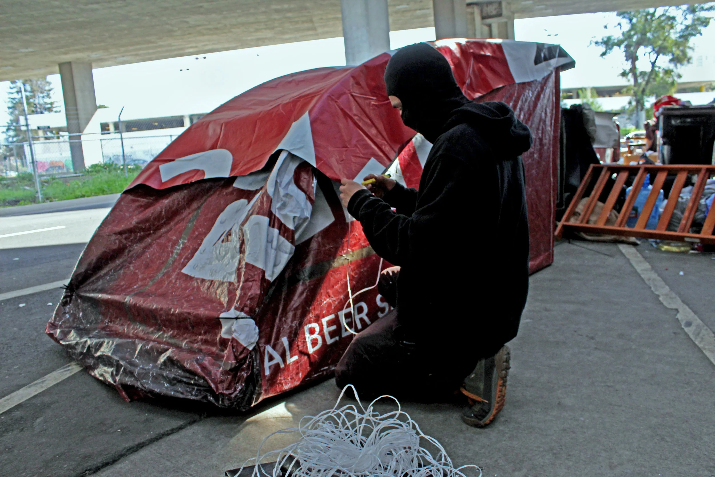 The tents were made from repurposed billboard vinyls. PEMEX (pictured), a prominent Bay Area graffiti writer, and his crew partnered with the activist collective Indecline for the project. Indecline gained national media attention for their series of naked Trump statues last year. Together they tore down a number of billboard vinyls across Oakland and repurposed them into handmade tents for the homeless. They call the project, "A House in Oakland."