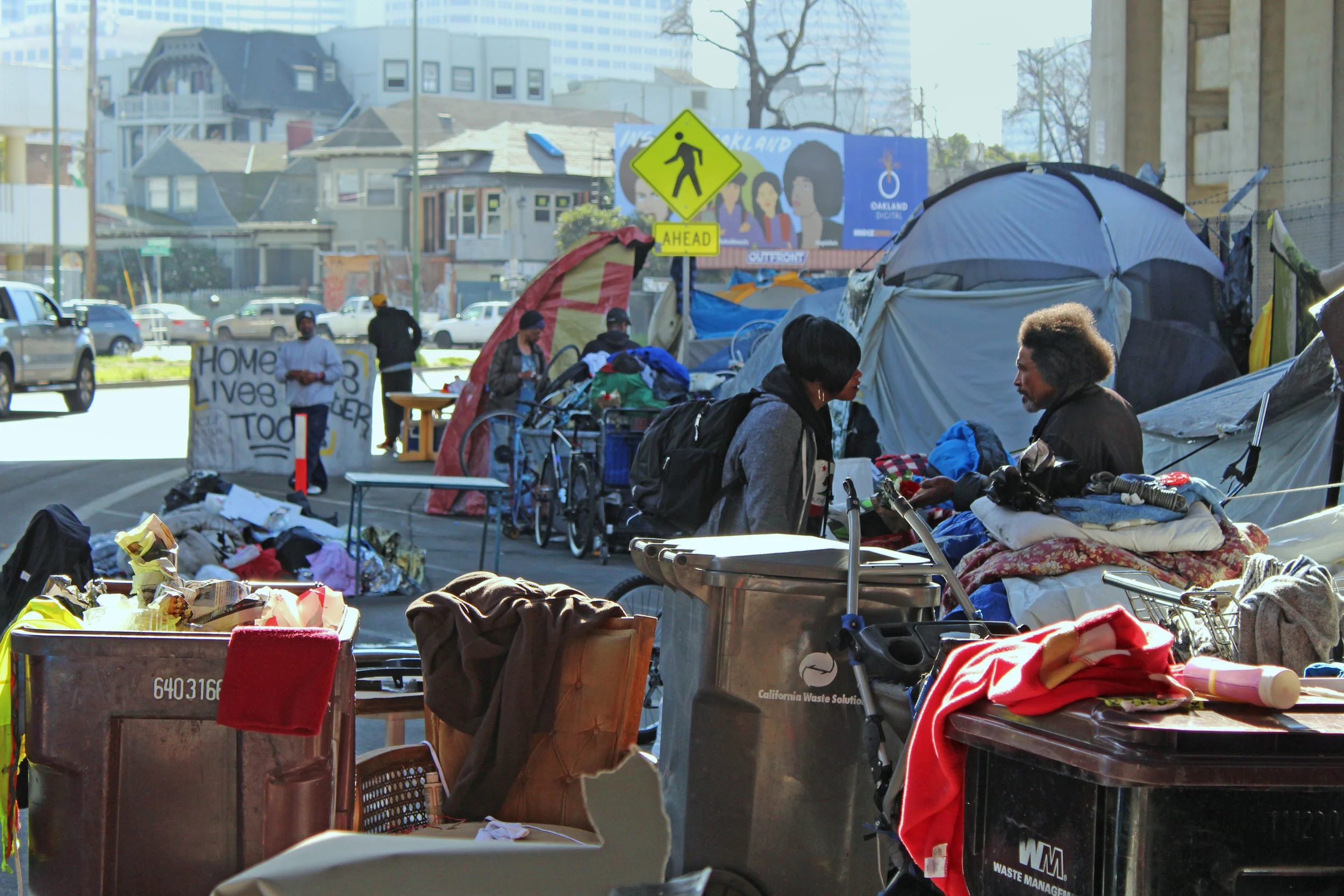 The Northgate encampment is located on Northgate Ave under the I-980 freeway. A sign in the background reads, "Homeless lives matter too."