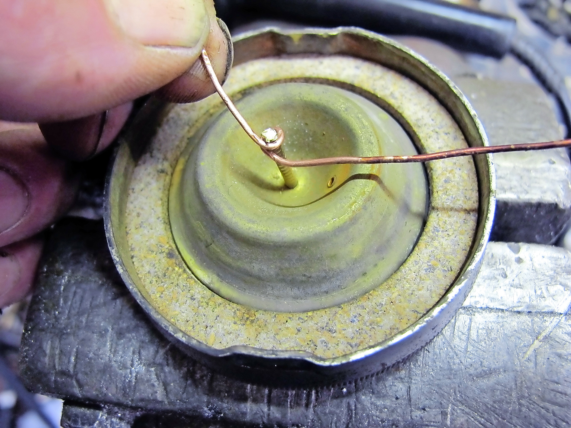 3. I wrapped a bit of copper wire around the rivet and soldered it in place. Then I enlarged the hole in the brass disc so that the wire and rivet would fit through.