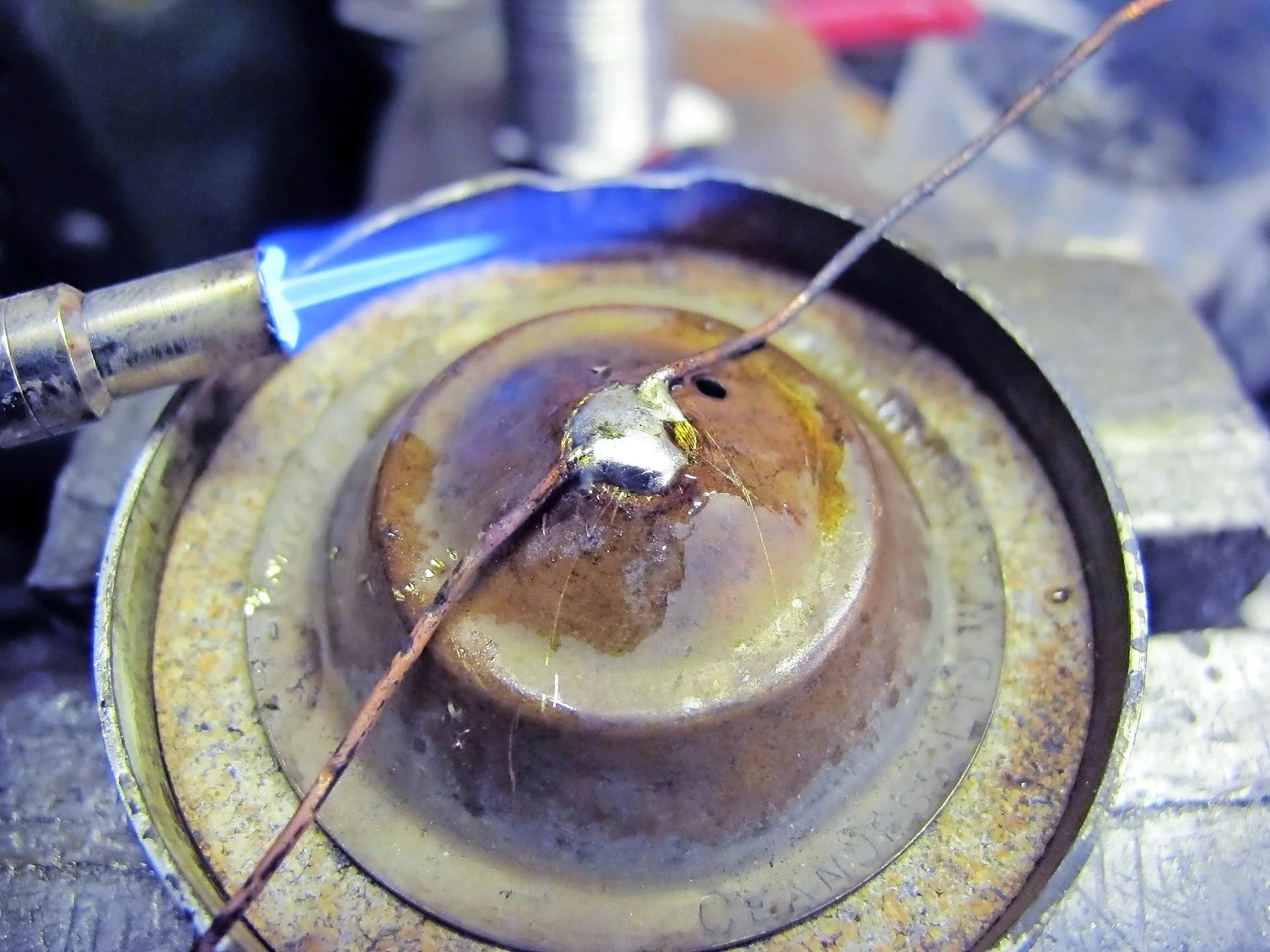 4. Then I was able to use the wire to pull the rivet into the hole and solder it in place. The wire can then be cut off or twisted into a loop for a security chain. Job done.