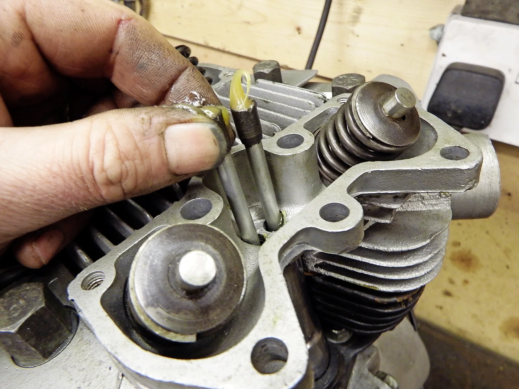 1. This is a 1960 500cc head, but the priciple’s the same for all Triumph twins. Locate pushrods in tappets with a blob of grease to prevent dislodging. Turn the engine till both are level.