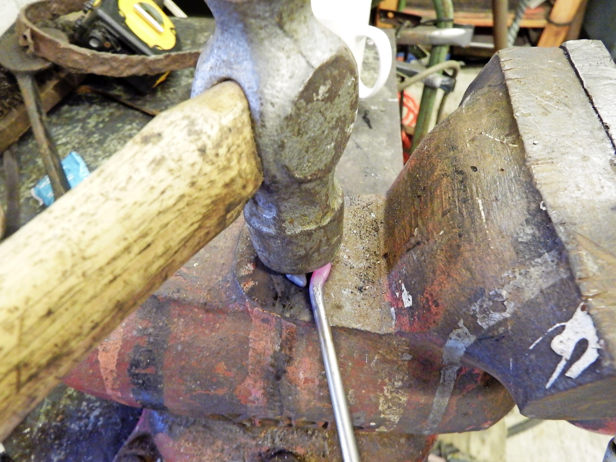 3. Tweak the loop back at the neck to make it symmetrical on the rod. Then, while still red hot, give it a few hammer blows to flatten the end for a bolt and washer.