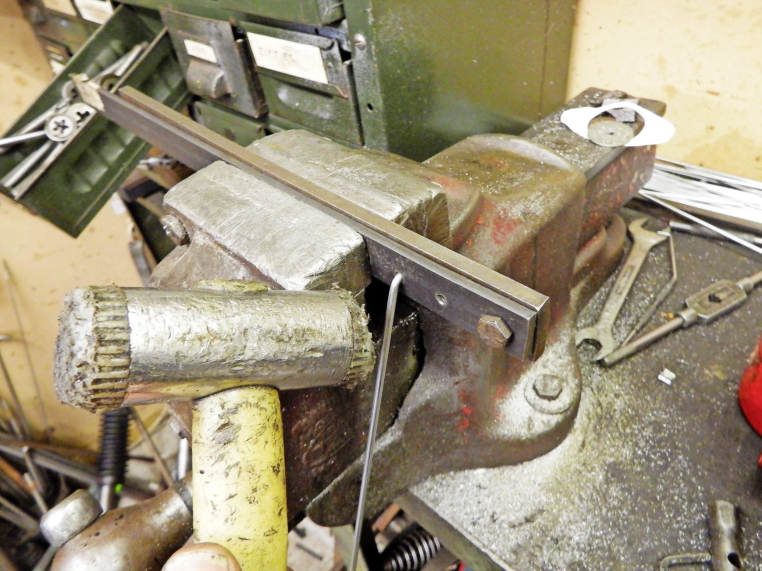 2. Insert the spoke into the jig, close it and tighten it in the bench vice. With the head gripped securely, you can now use a soft hammer to bend the spoke to the desired angle.