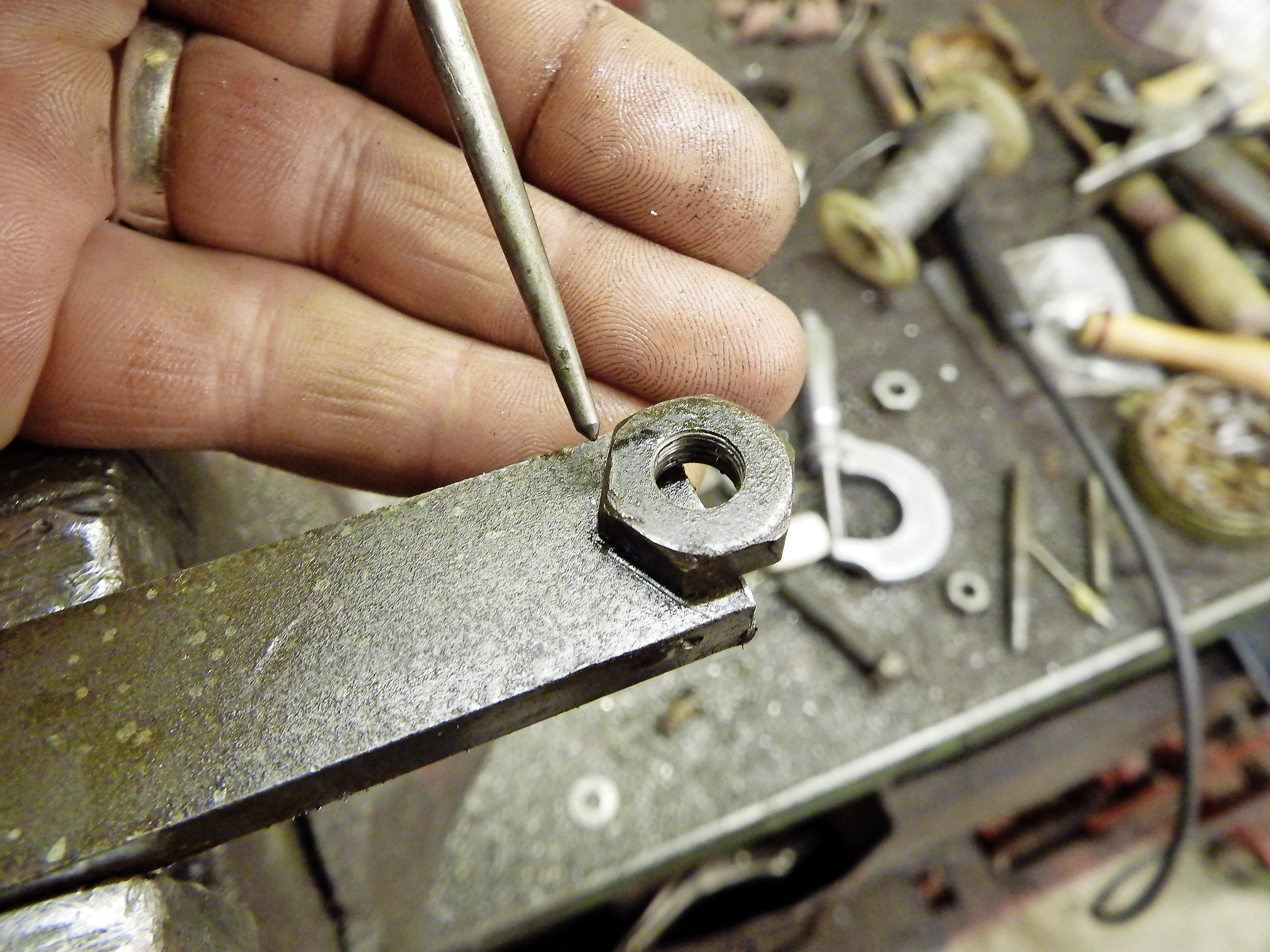 2. Next I positioned a nut in the best position to align with the drilled hole and scored around it, centre-punching at the apex and drilling a small hole.