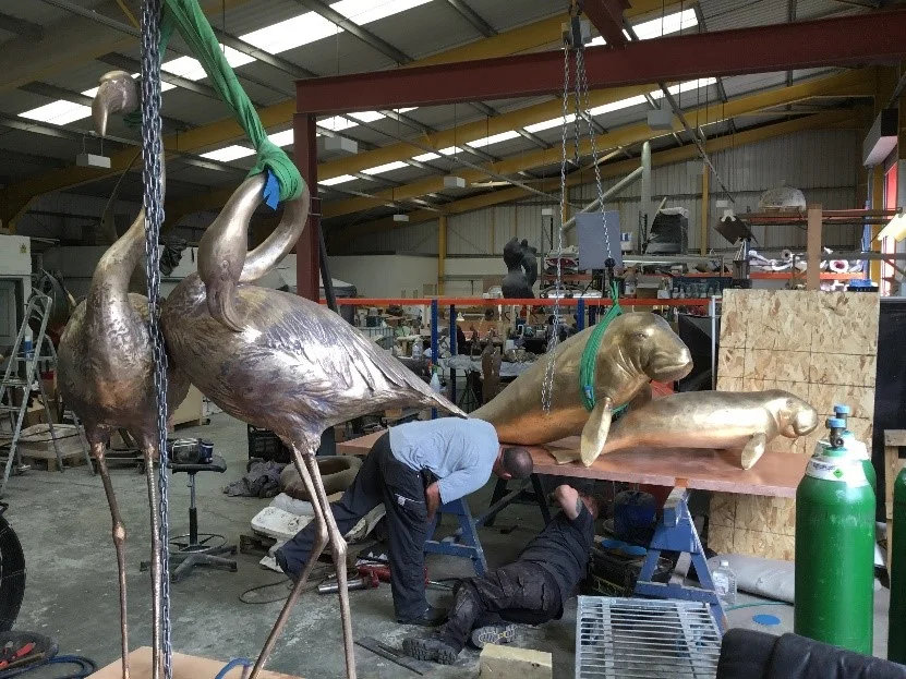 Chasers working on the Dugong base, Flamingos awaiting patination in the foreground