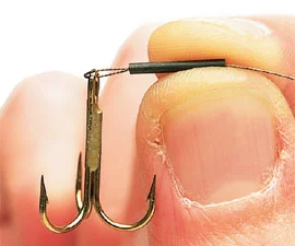 2. Cut off 18 inches of wire, thread on a crimp, pass the wire through a treble hook and thread it back, well inside the crimp.