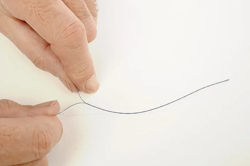Take the mainline or shockleader between thumb and first finger of both hands and twist in opposite directions to twizzle it together.