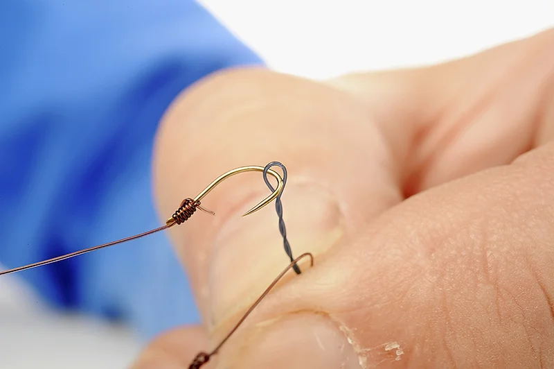 Put the hook itself through the end loop in the twisted boom. Then pull the whole hooklength through with it as it goes through.
