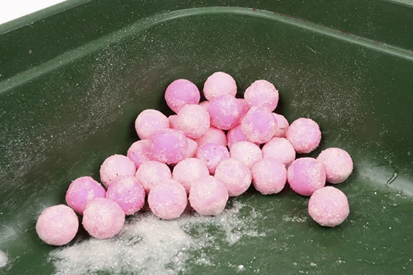 Add another teaspoonful of flavour, followed by a powder such as super-sweet pH trigger. Roll the baits to cover.
