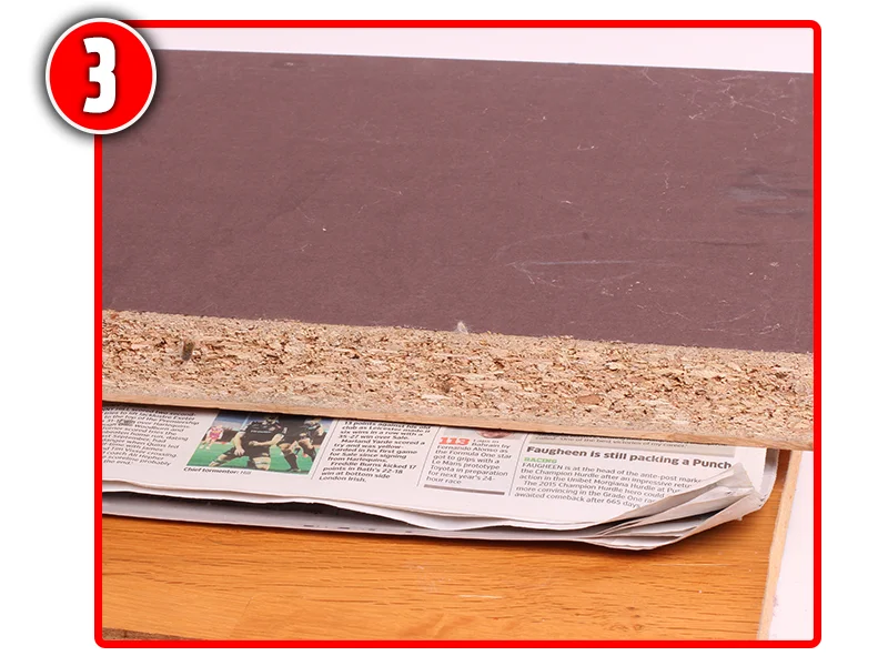 Cover with more newspaper and lay a piece of board over the top.