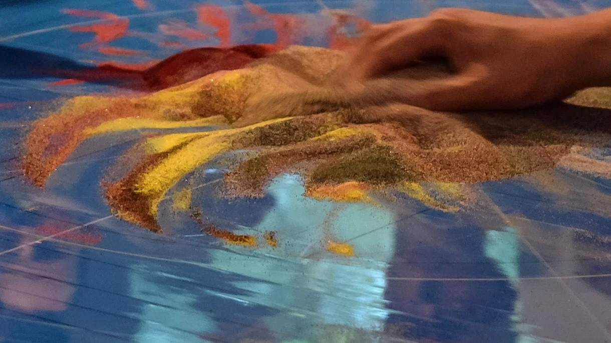 The sand is swept up into a vase, wrapped in silk, and transported to a river (or other moving body of water) where it is dispersed back into nature.