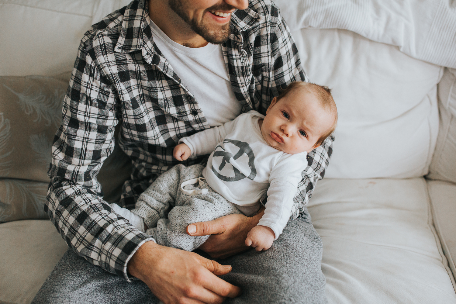 Dad holding 2 month old baby boy on couch {Toronto Family Photographer}