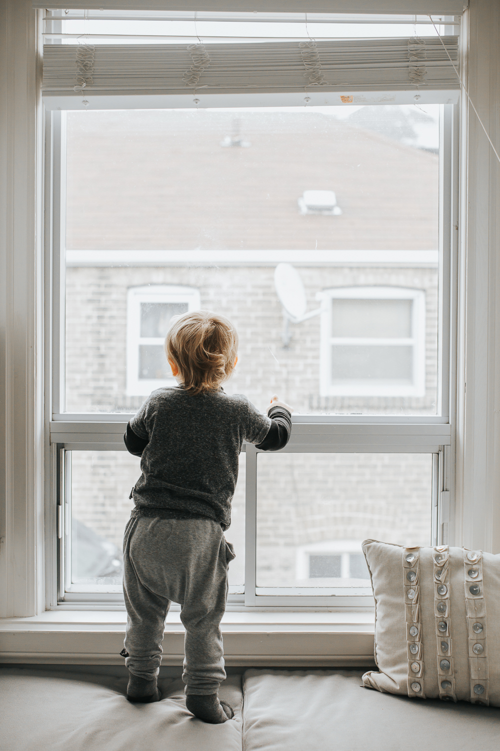 2 year old toddler boy looking out winder {Toronto Family Photographer}