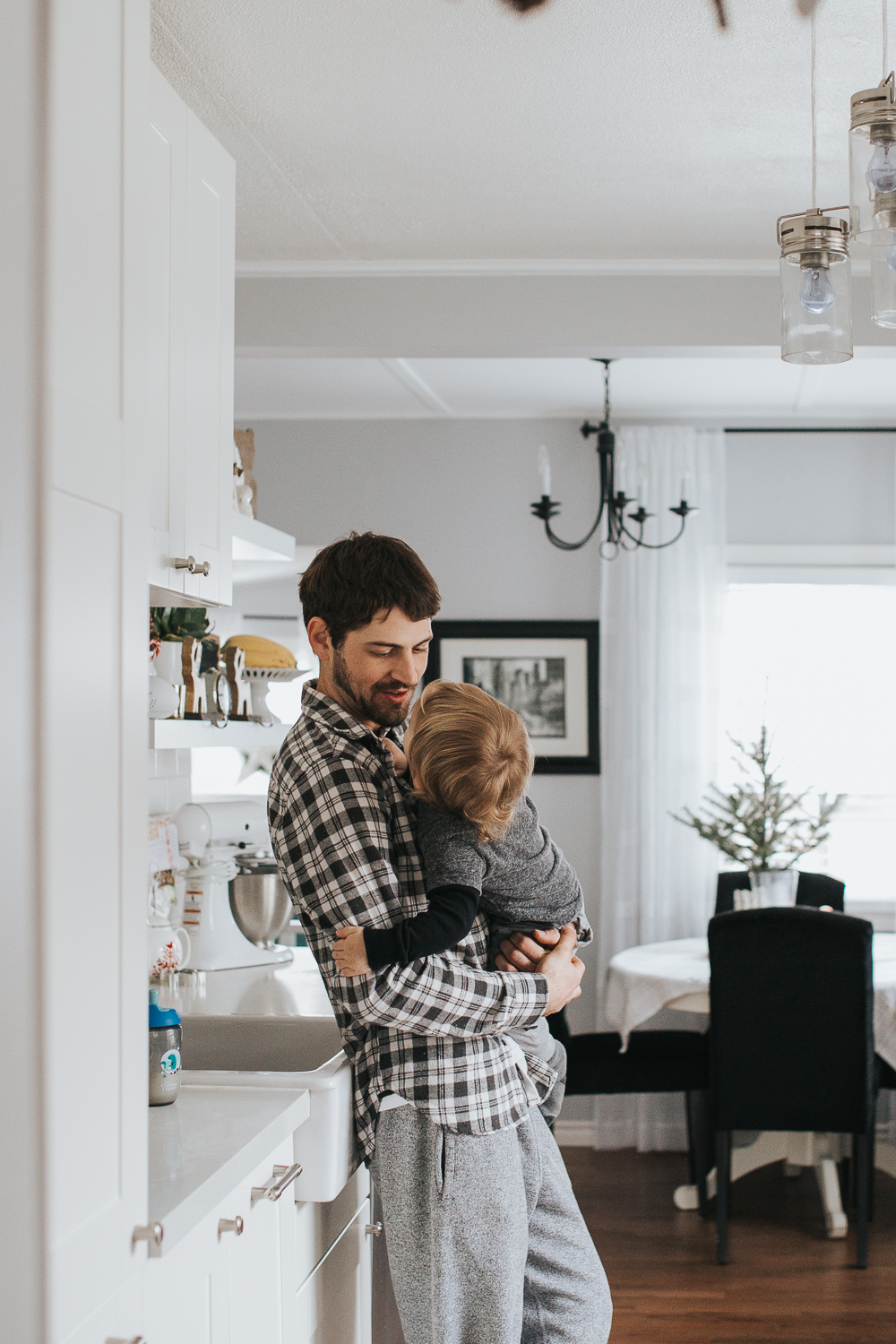 Dad holding 2 year old toddler boy in kitchen {Toronto Family Photographer}