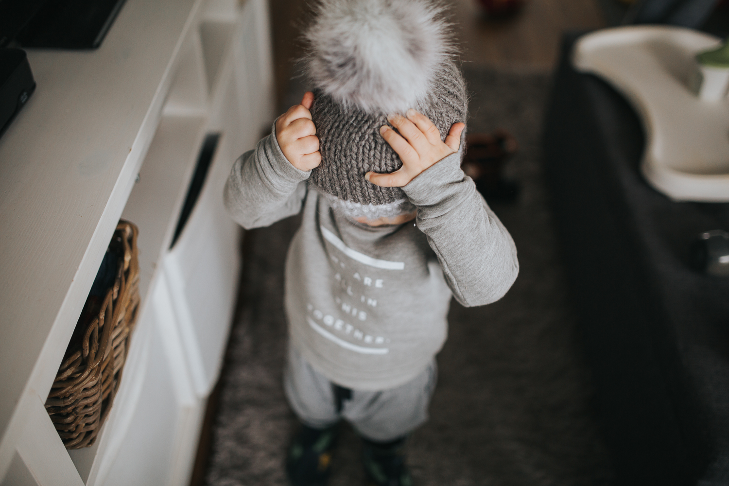 2 year old toddler boy putting hat on {Toronto Family Photographer}