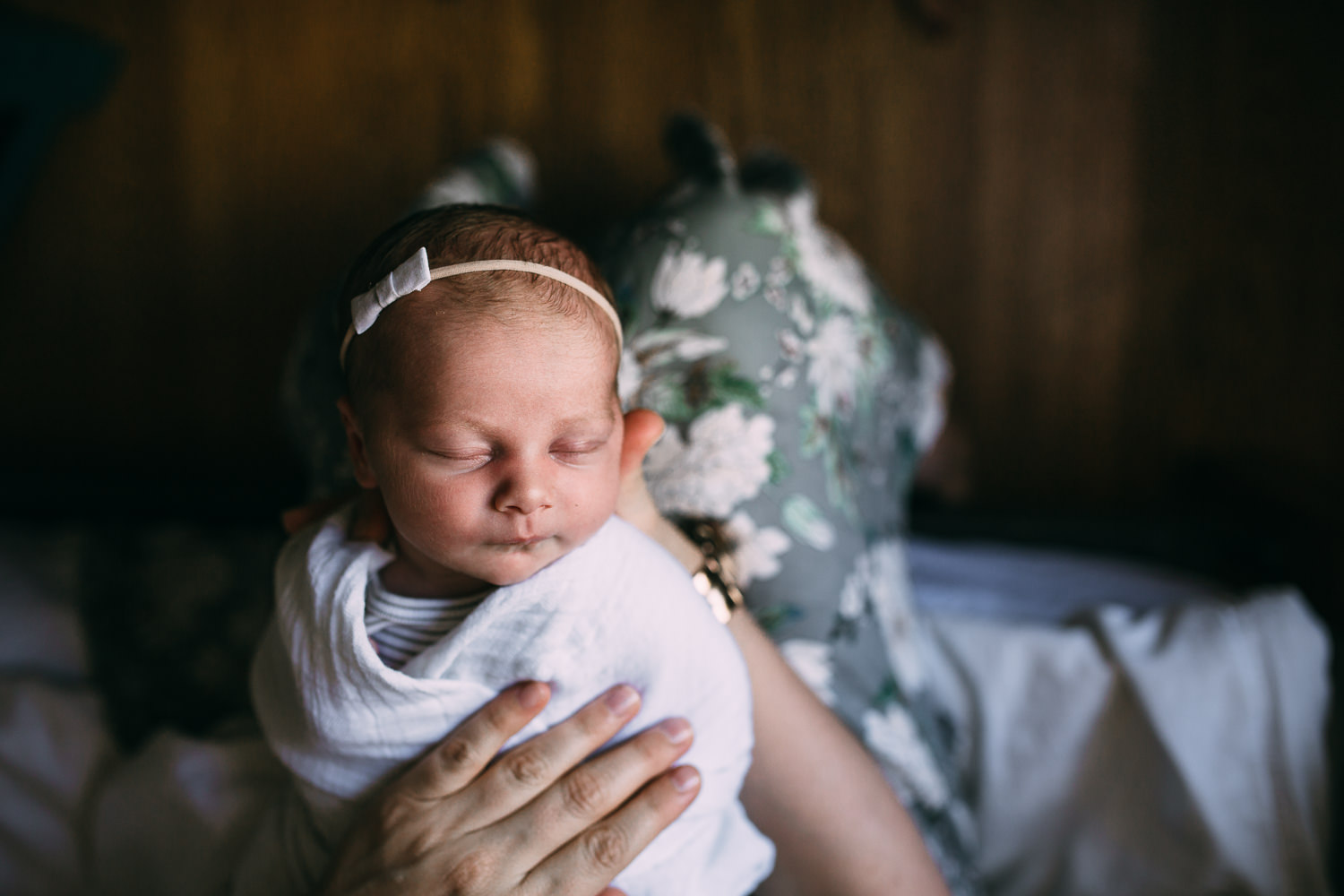 newborn baby girl asleep in mother's arms - Uxbridge in-home photos