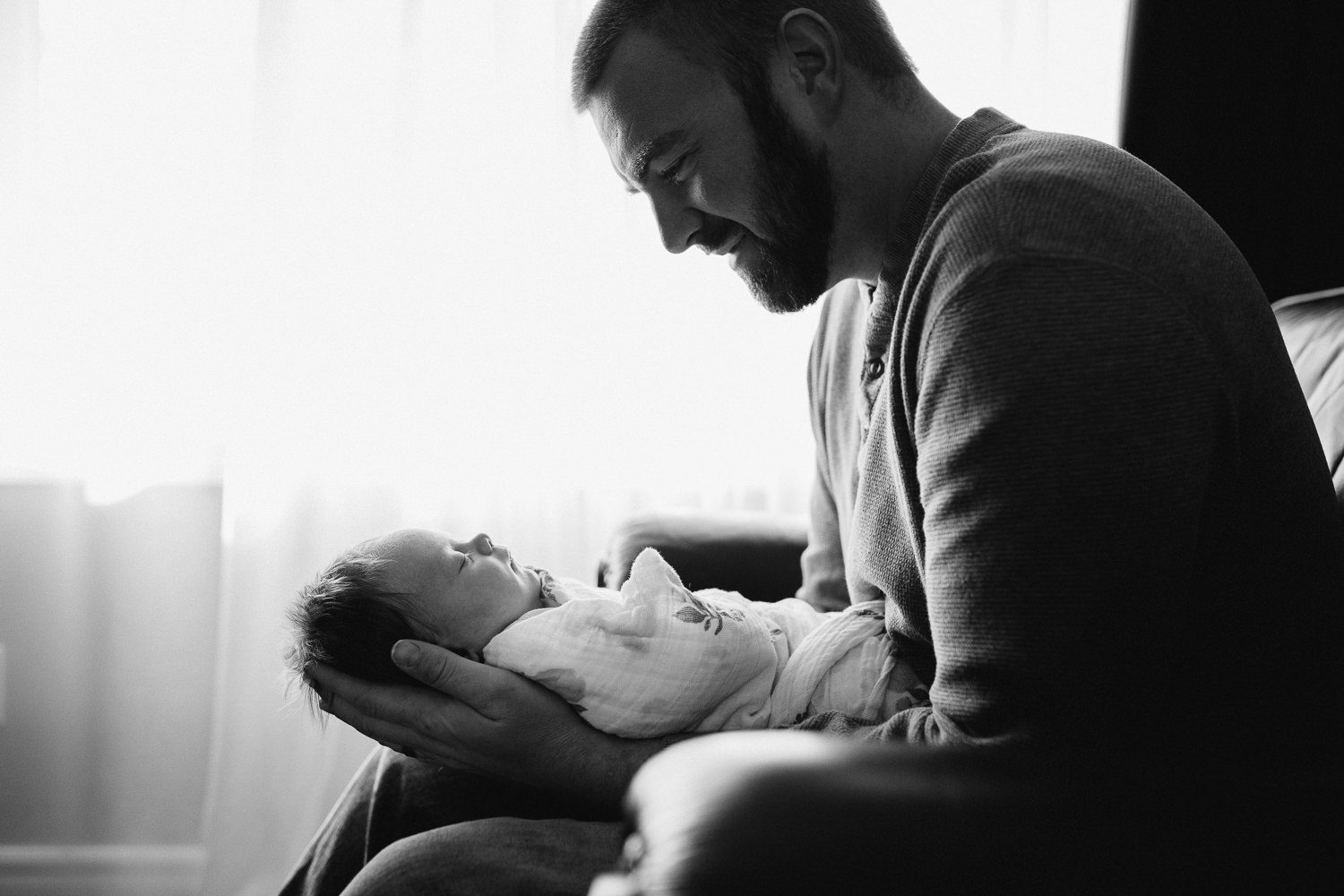 father holding and looking at 1 month old baby girl - Newmarket baby photography