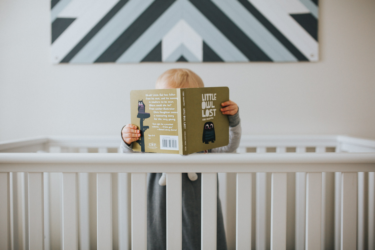 1 year old boy reading in crib - Newmarket child photography