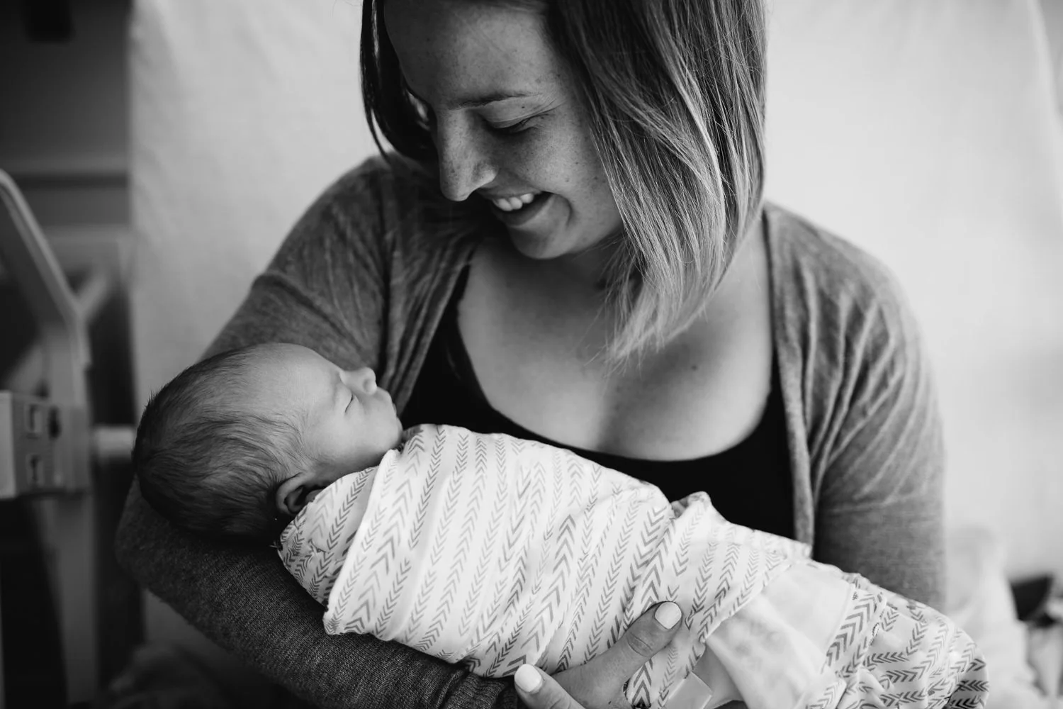new mom holding newborn baby boy on hospital bed - Newmarket Fresh 48 photography